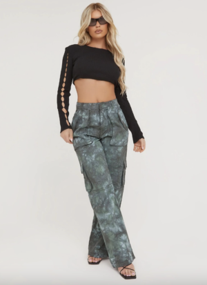 blonde lady wearing blue patterned cargos, black crop top and sunglasses